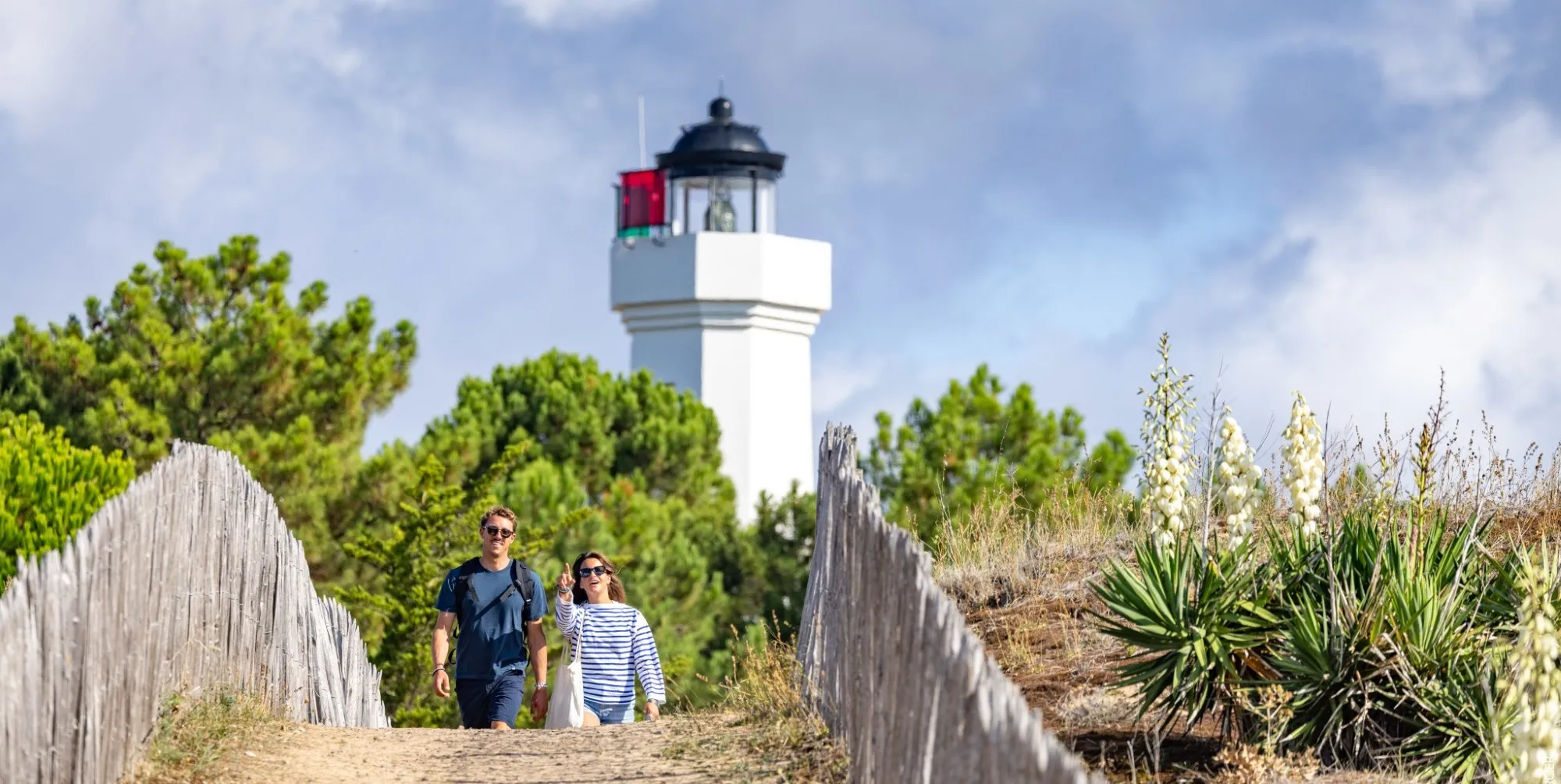 Promenade vers le phare de La Tranche-sur-Mer entre dunes et ganivelles.